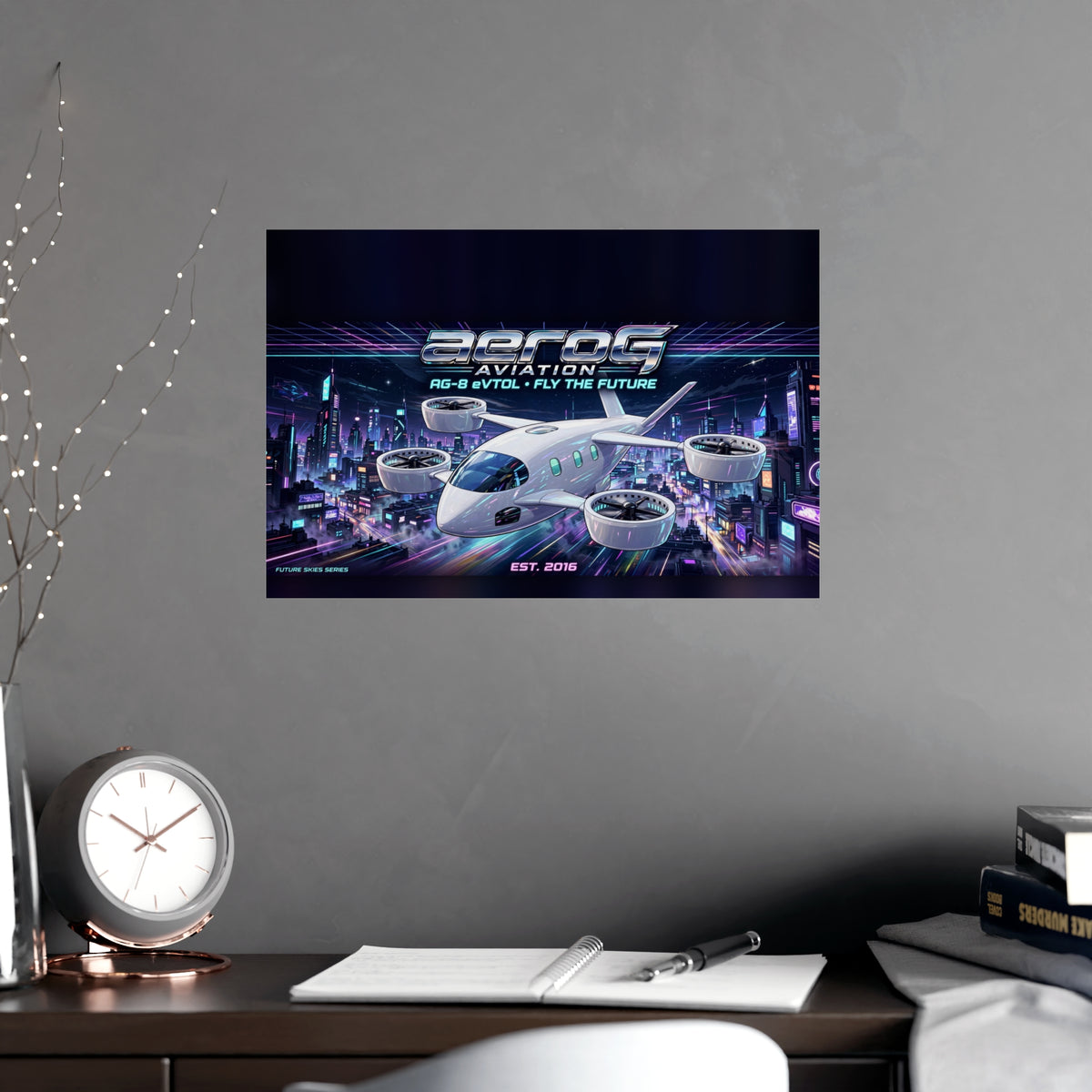 Neon City poster hanging on a gray wall above a desk with a clock and notebook